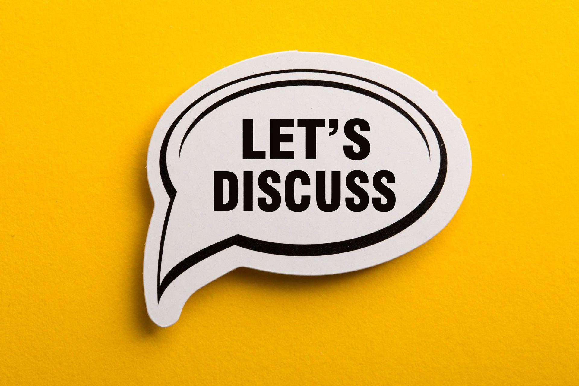Let Us Discuss Speech Bubble Isolated On Yellow Background